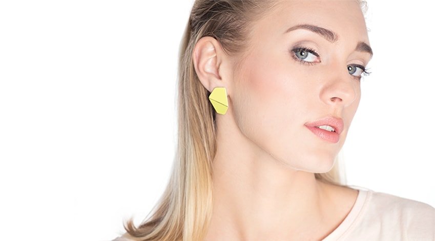 1. Woman wearing Lisa Kroeber Jewellery Folded Wide Earrings in yellow, showcasing elegant design