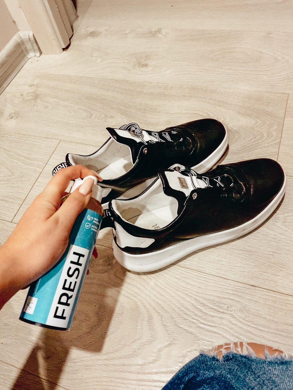 2. GoGoNano shoe freshener being sprayed on black sneakers, showcasing odor-neutralizing action