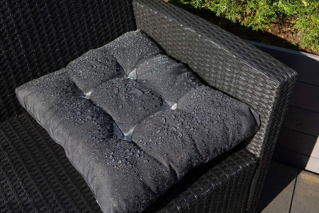 3. Black cushion on outdoor chair with water droplets, showing GoGoNano's protective coating on textiles