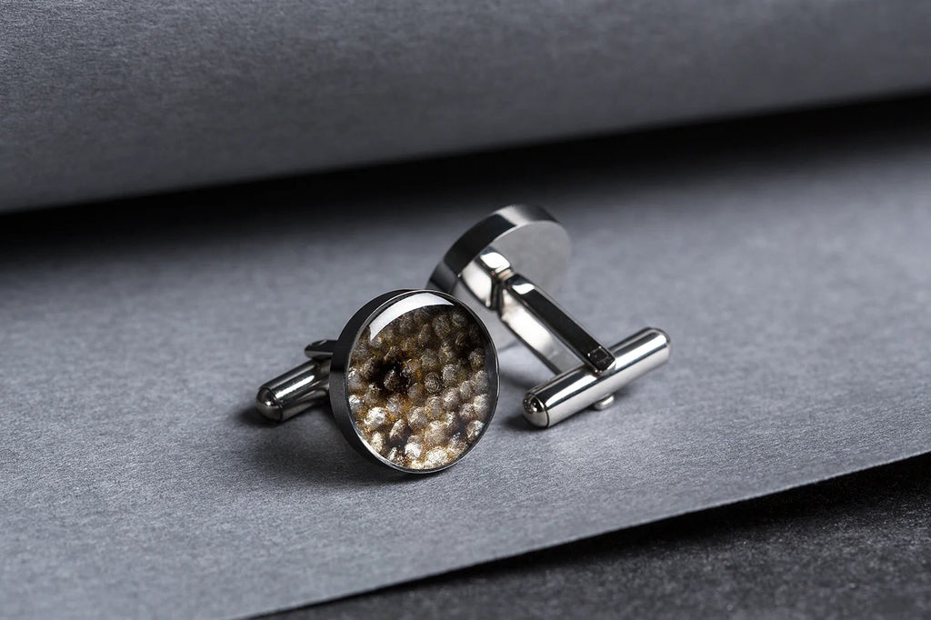 2. Pair of Eherüs round cufflinks with black-spotted leather on grey background