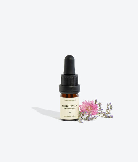 1. Smells Like Spells Helichrysum Essential Oil in 5 ml glass bottle with pipette, shown with flowers