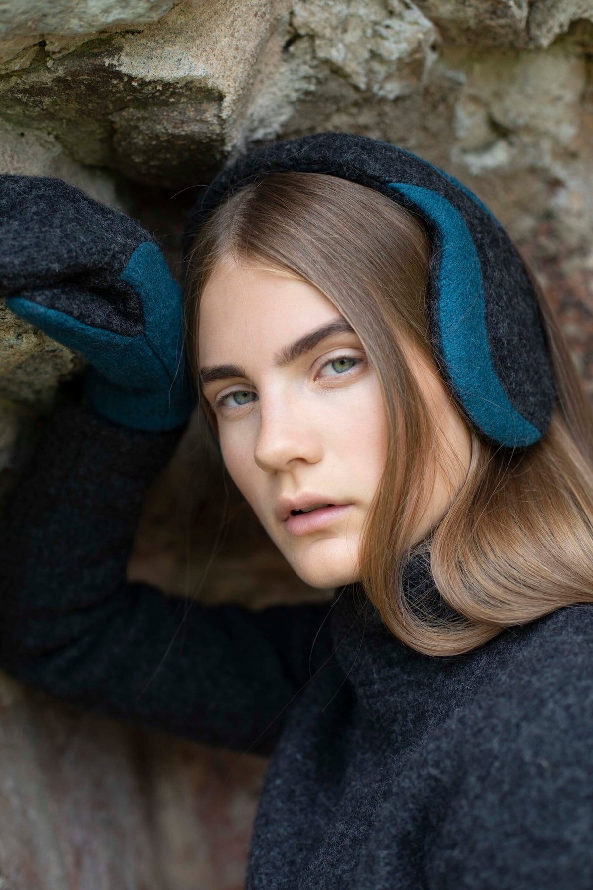 1. Woman wearing HERTTA felted wool earmuffs in medium grey, styled outdoors