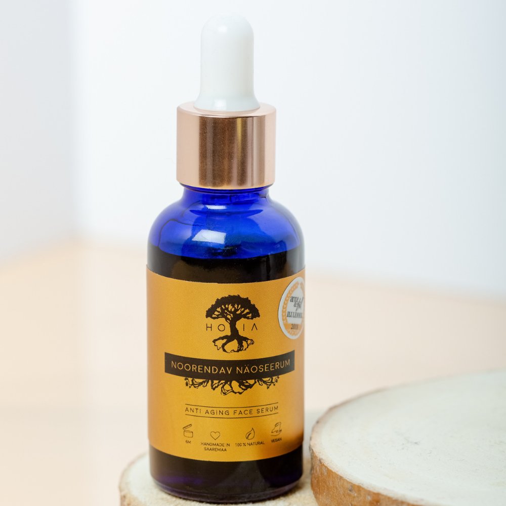 2. HOIA homespa Anti-Aging Face Serum in blue glass bottle with gold label, studio setting on wooden surface