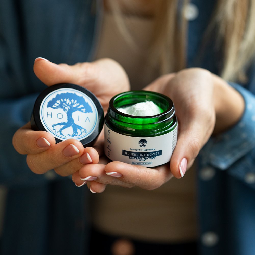 2. HOIA homespa Soothing Face Cream Blueberry Boost held by a woman, showing product texture and packaging