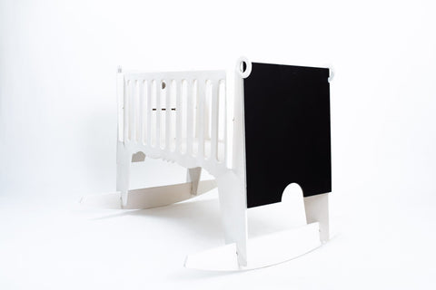 3. Side view of white Adensen birchwood cradle with blackboard end panel on white background