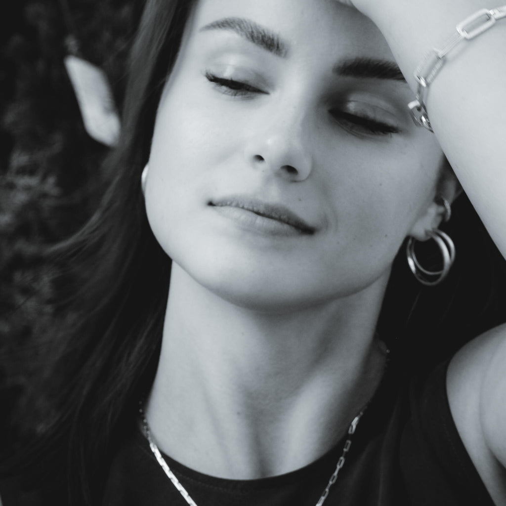 1. Woman wearing MyaMoon Sugar Hoops L Earrings in silver, showcasing Nordic minimalism and elegance