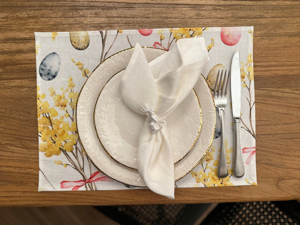 1. Easter Happy table placemat by Hortensias Home with white napkin and silverware on wooden table