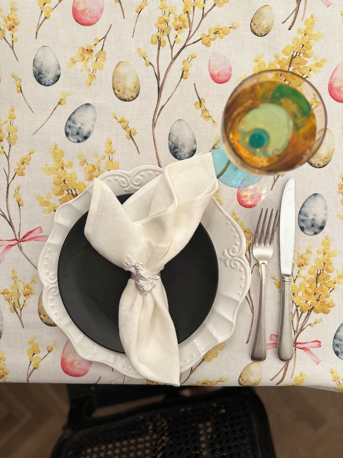 2. Close-up of Easter Happy tablecloth by Hortensias Home, showcasing colorful egg and floral design with table setting