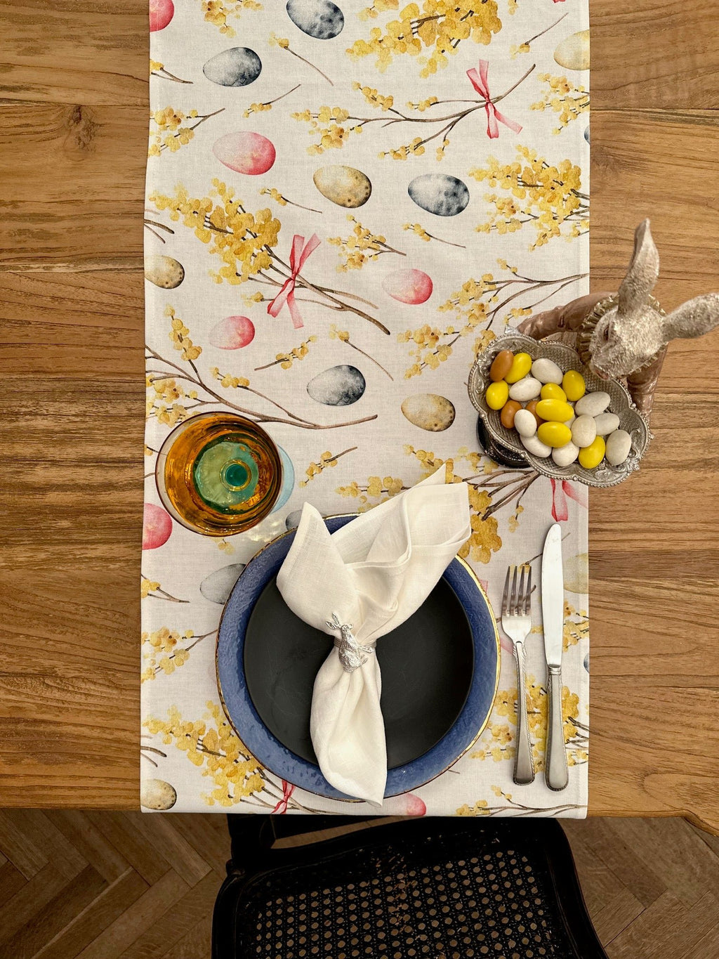 1. Easter Happy table runner by Hortensias Home on wooden dining table with festive decor, featuring colorful egg and floral print