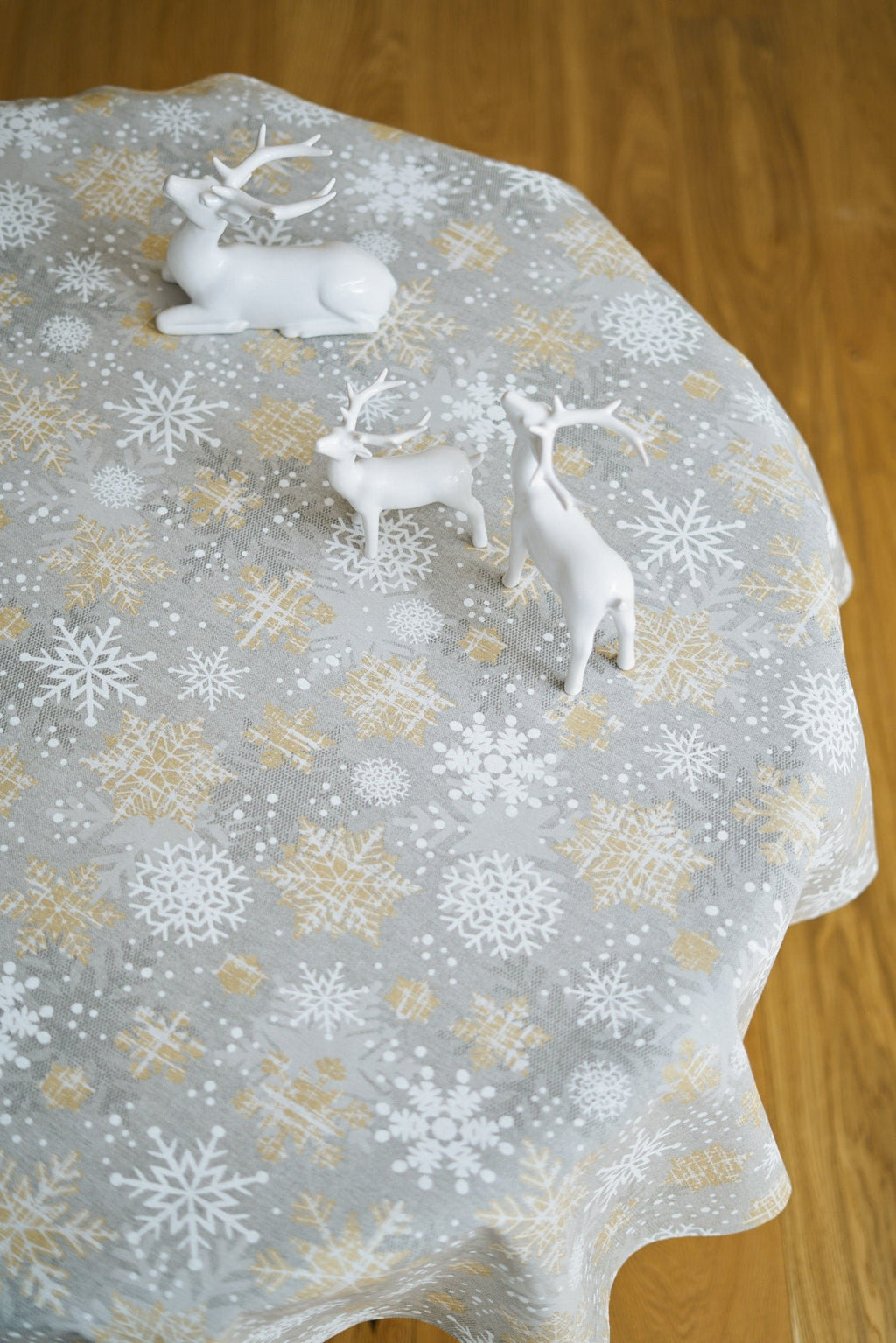 2. Top view of Hortensias Home festive snowflake tablecloth in gold and grey with reindeer decor