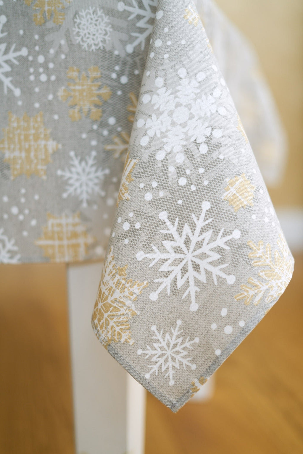 5. Close-up of corner detail on Hortensias Home Winter Motive Snowflakes tablecloth with gold and grey pattern
