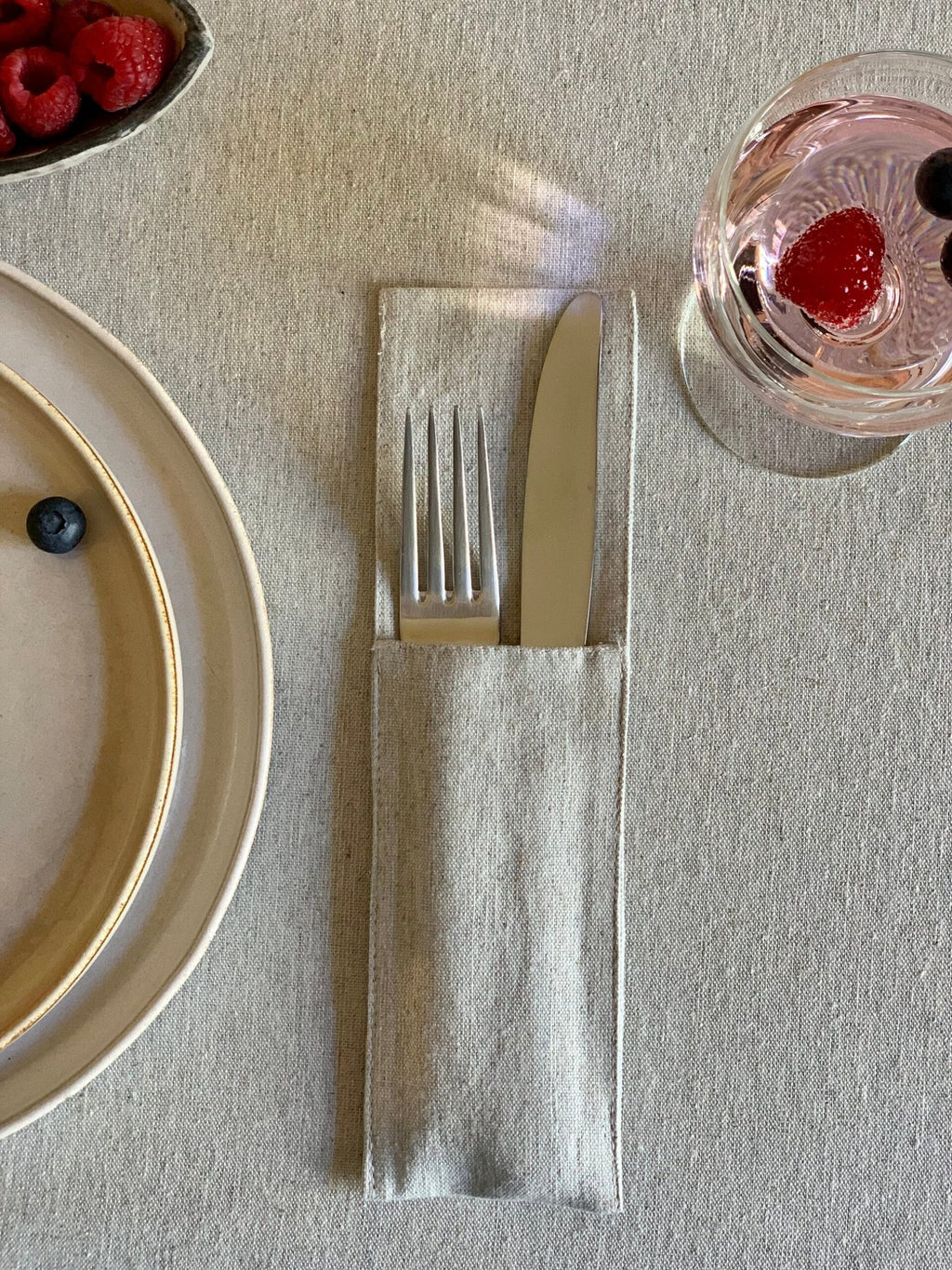 3. Close-up of beige tablecloth with cutlery and glass, emphasizing texture and sustainable material