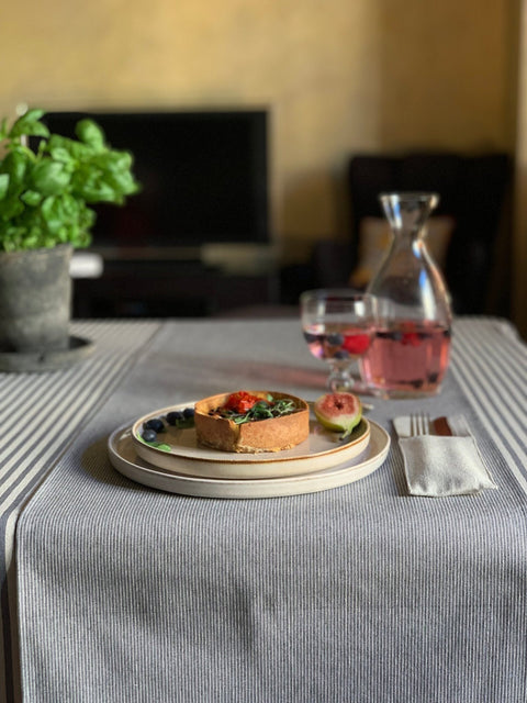 4. Indoor dining setup featuring Hortensias Home Nord 2 table runner with blue stripes, styled with a plate of food and a drink