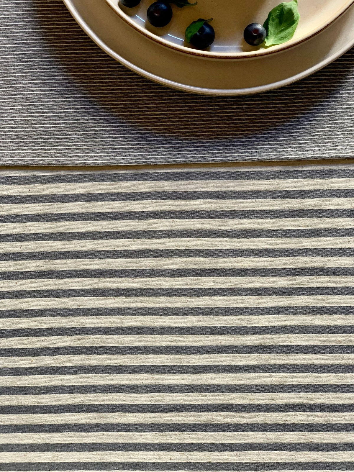 4. Close-up of blue striped pattern on Nord 1 table runner by Hortensias Home, with plate detail