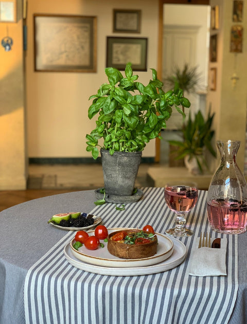 2. Dining setup featuring Nord 1 table runner with blue stripes by Hortensias Home, shown with food and drink