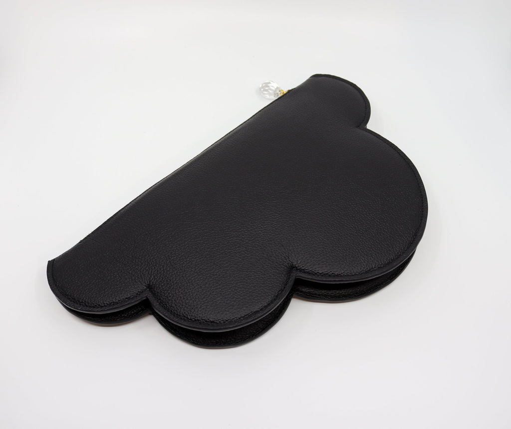 4. Flat lay of Tairi Roosve Leather Clutch Bag Cloud in black, showing cloud silhouette and texture