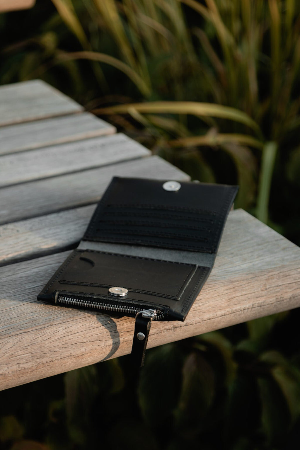 7. Lava flow Classic Leather Wallet MINI TAAL in black open on a wooden surface, showing card slots and coin section