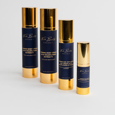 2. North Beauty Firming Body and Face Kit featuring body cream, serum, day cream, and eye cream with wildflower extracts, shown in studio with gold and navy design
