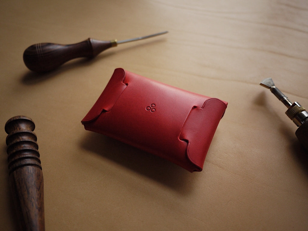 4. Back view of Mirgoods red leather wallet showing folded construction, with crafting tools