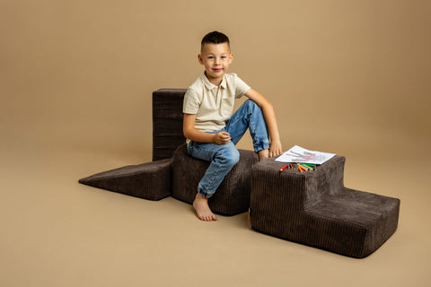 1. Boy sitting on brown velvet corduroy play set with drawing materials on beige background