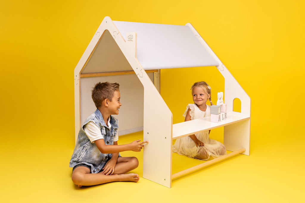 1. Two children playing inside a MeowBaby white wooden house with a blue roof on a yellow background