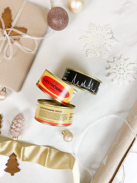 2. SEIK Socks in a Tin Can Gift Set with Surströmming and Tallinn designs, shown in a holiday-themed setting