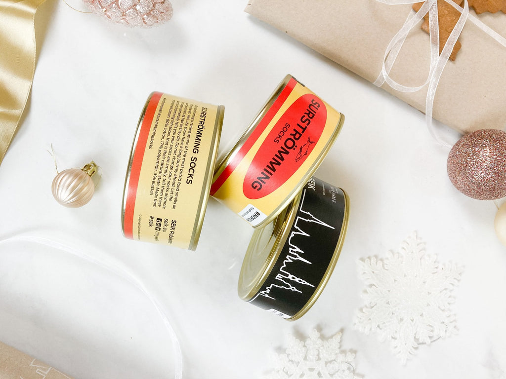 3. Close-up of SEIK Socks in a Tin Can Gift Set, highlighting Surströmming and Tallinn designs with festive decor