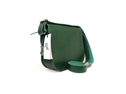 5. Side view of Zelma Kraft green leather saddle bag with adjustable strap and brand tag