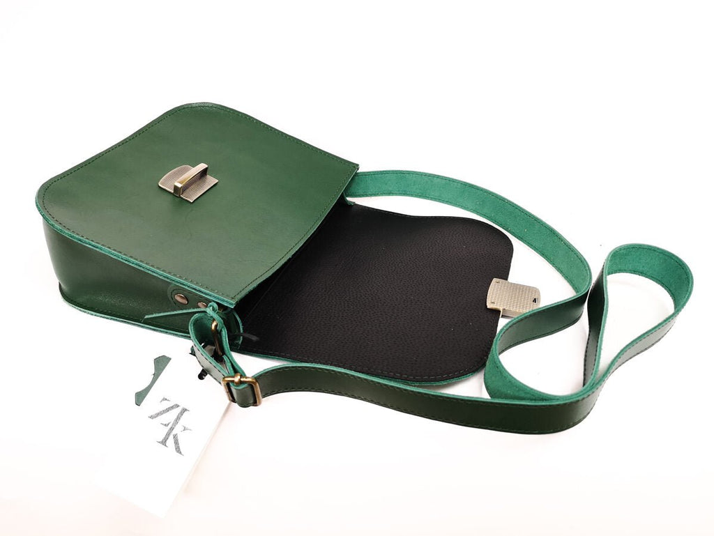 8. Woman with Zelma Kraft green leather saddle bag and backpack, showcasing versatility and style