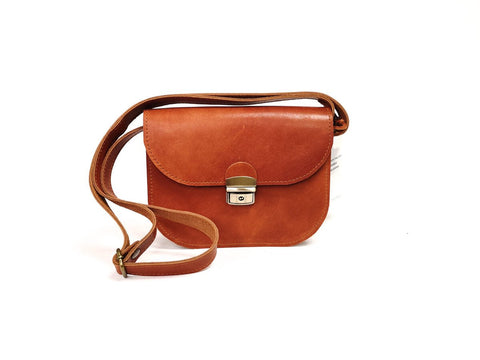 3. Studio image of Zelma Kraft light brown leather saddle bag with adjustable strap and buckle closure