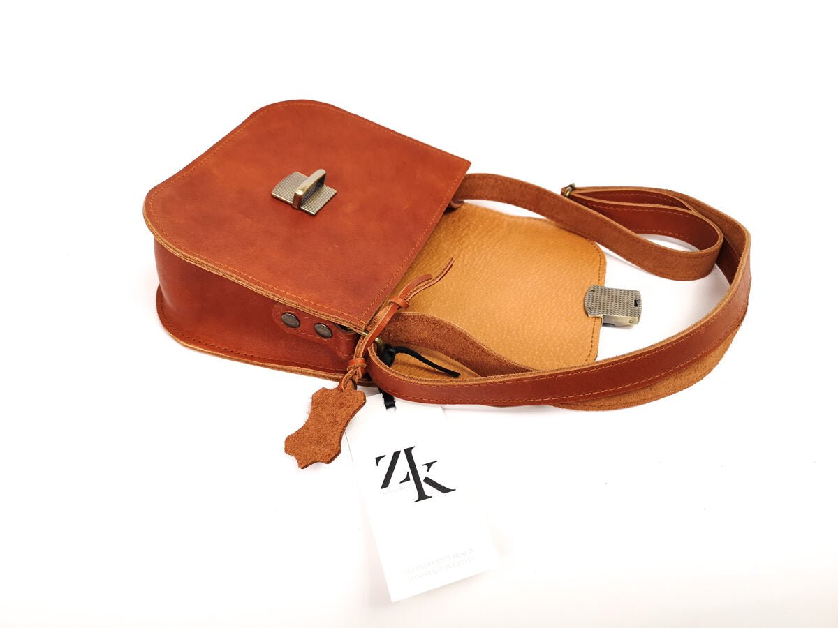 5. Open Zelma Kraft saddle bag in light brown, showing interior with natural pigskin leather lining and brand tag