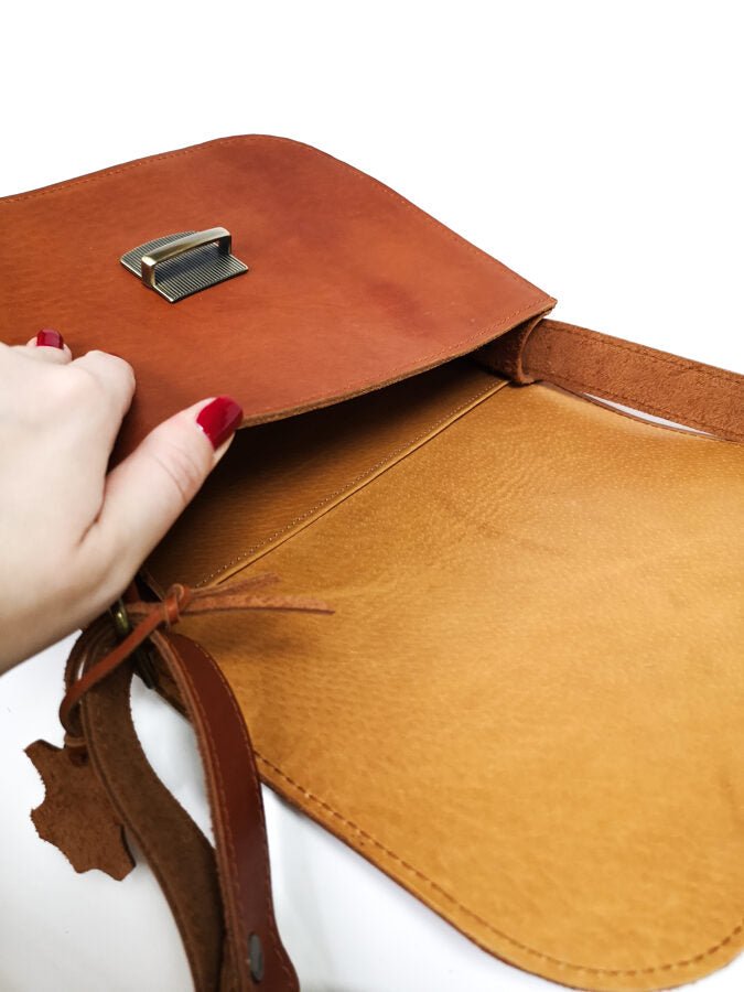 6. Close-up of Zelma Kraft natural leather saddle bag in light brown, highlighting interior and buckle detail