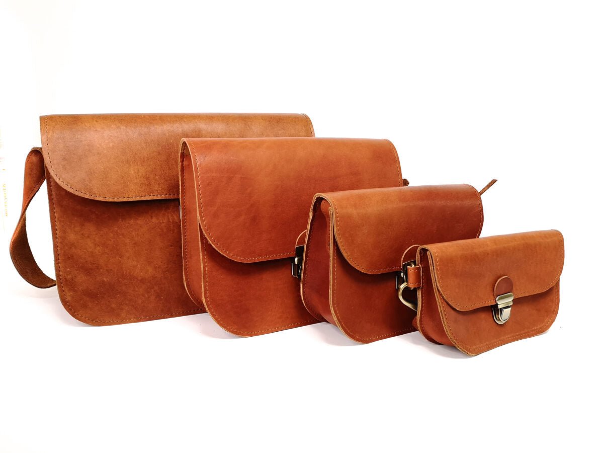 7. Collection of Zelma Kraft leather saddle bags in various sizes, all in light brown, shown in studio