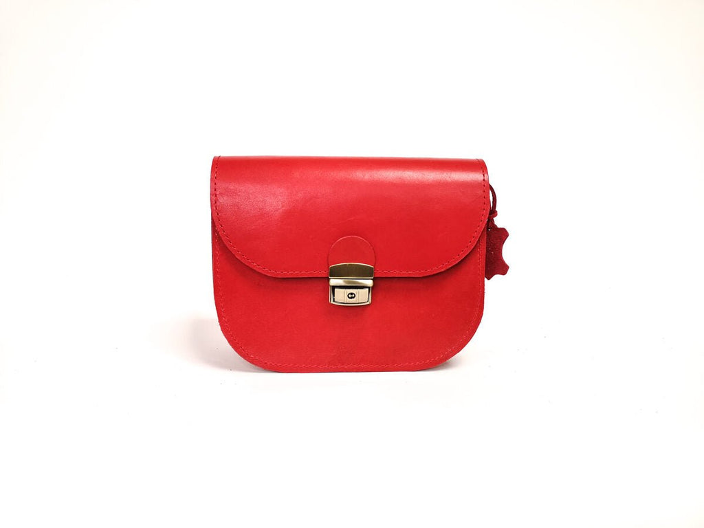 12. Studio image of Zelma Kraft red natural leather saddle bag, highlighting semi-gloss finish and buckle closure