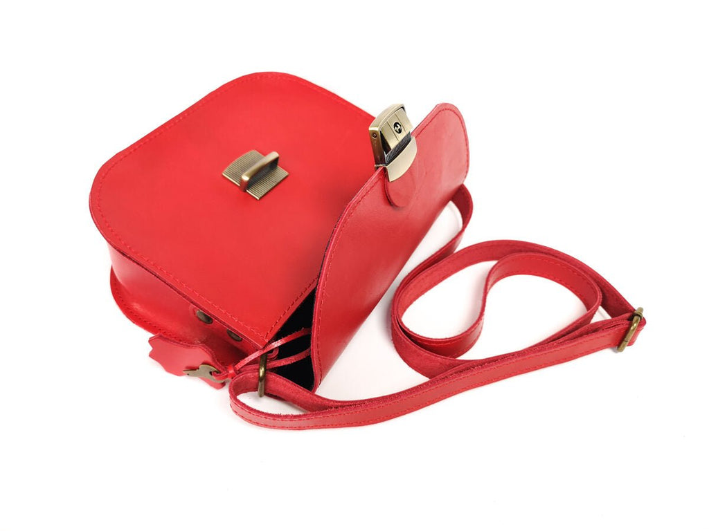 8. Open view of Zelma Kraft red leather saddle bag, displaying interior space and buckle closure