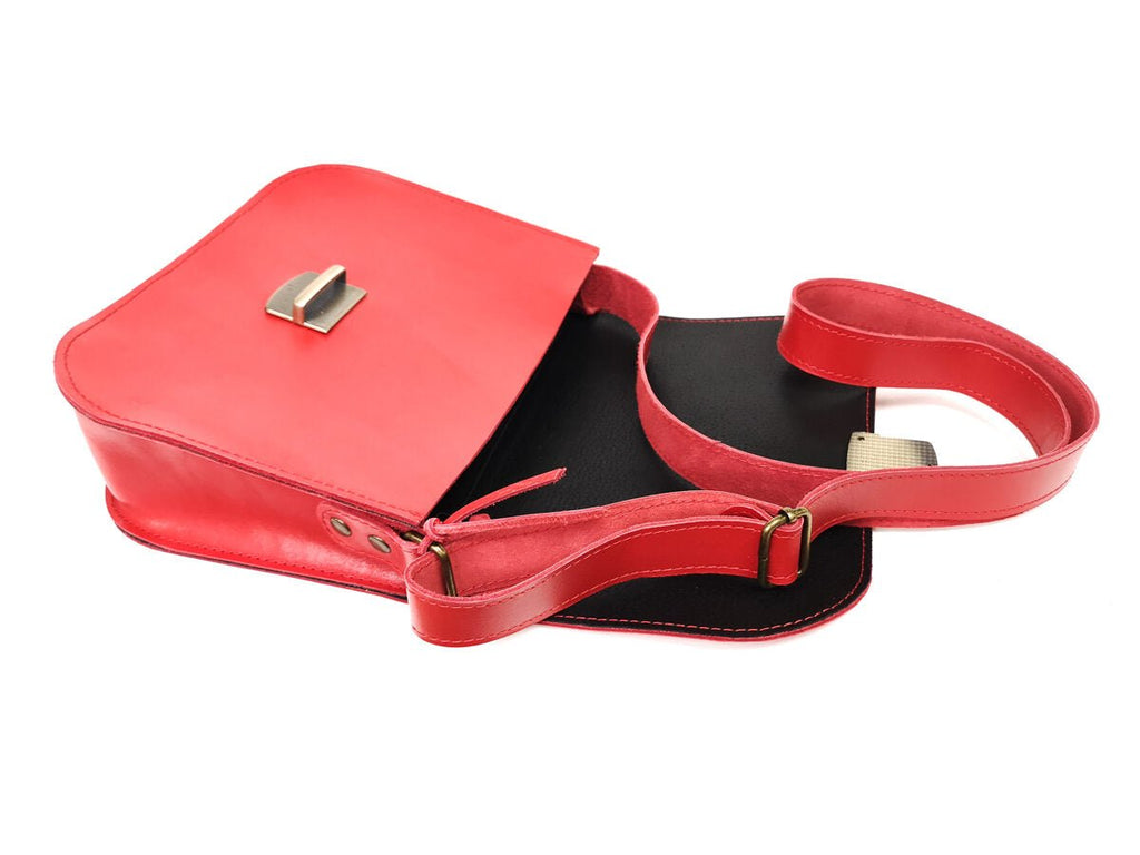 5. Open view of Zelma Kraft red natural leather saddle bag showing interior with black lining and adjustable strap