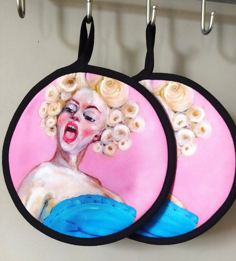 2. Two round pot holders with pop art style paintings of a woman with blonde curls and a blue dress hanging on hooks