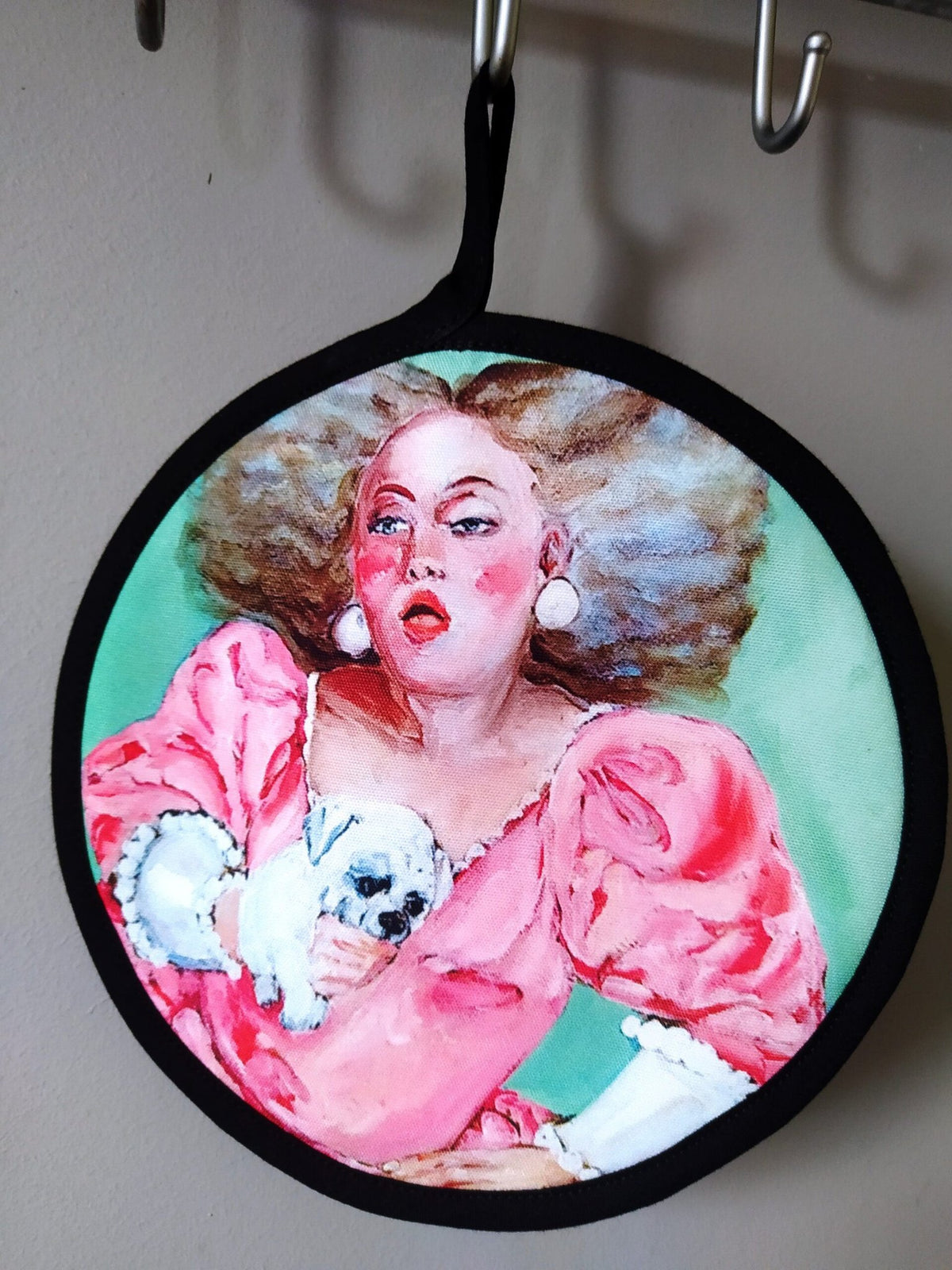 4. Single pot holder with pink dress woman and dog design hanging on hooks