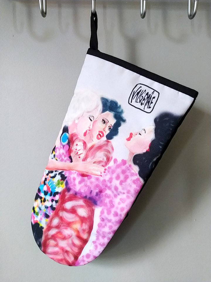 2. Katrin Valgemäe oven glove hanging on a hook, showcasing pop art design with three women, polyester and cotton blend