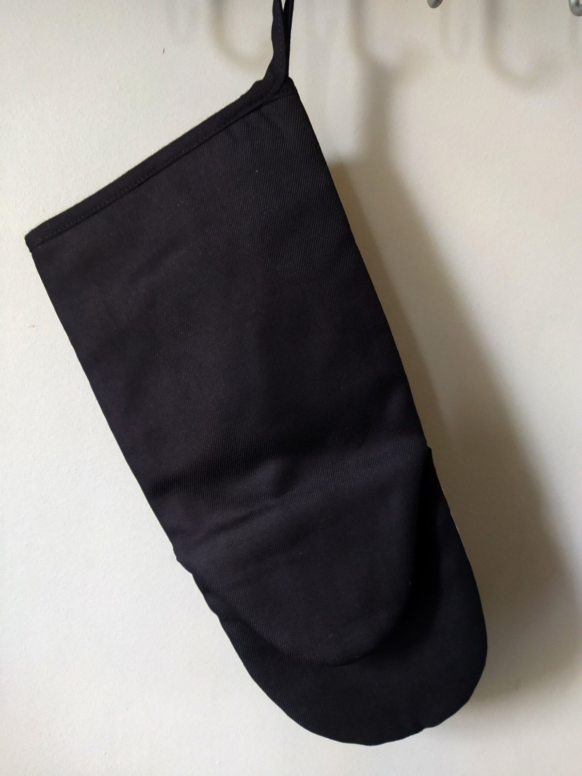 2. Back view of black Katrin Valgemäe oven glove hanging on a hook
