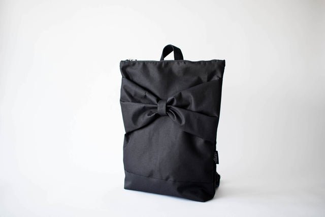 3. Studio image of Muni Black Bow Large waterproof backpack, featuring large bow design and zipper closure
