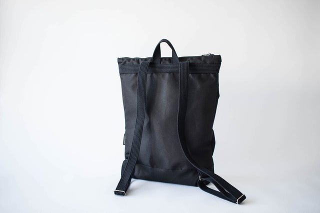 7. Back view of Muni Black Bow Large waterproof backpack, showing adjustable shoulder straps and durable design