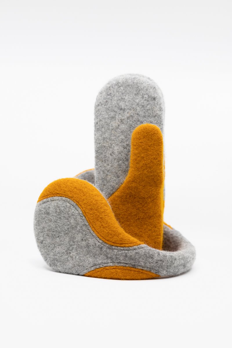 2. Side view of HERTTA felted wool earmuffs in light grey and curcuma, highlighting lightweight and comfortable fit
