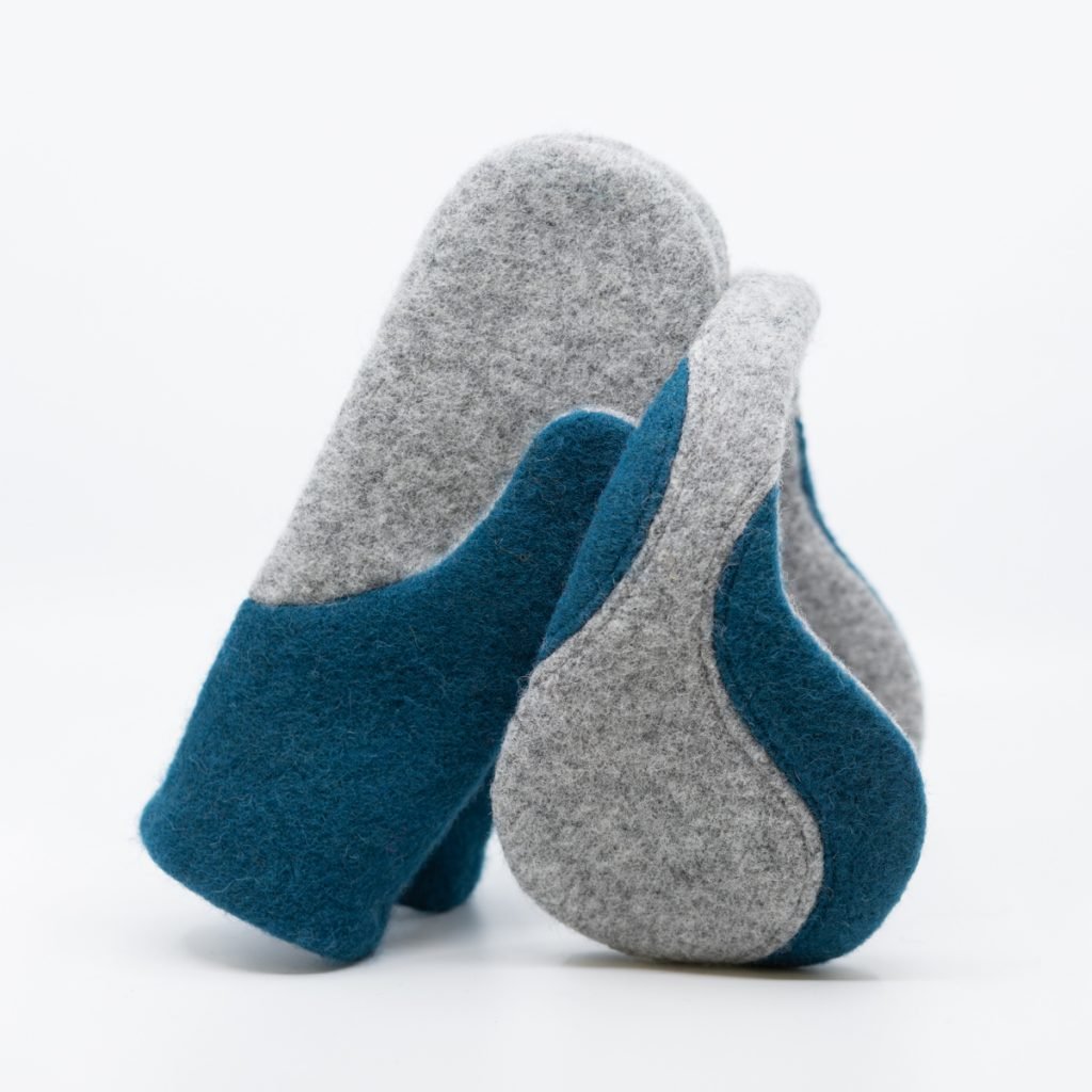 2. Pair of HERTTA felted wool earmuffs in light grey and aquamarine, displayed upright in studio