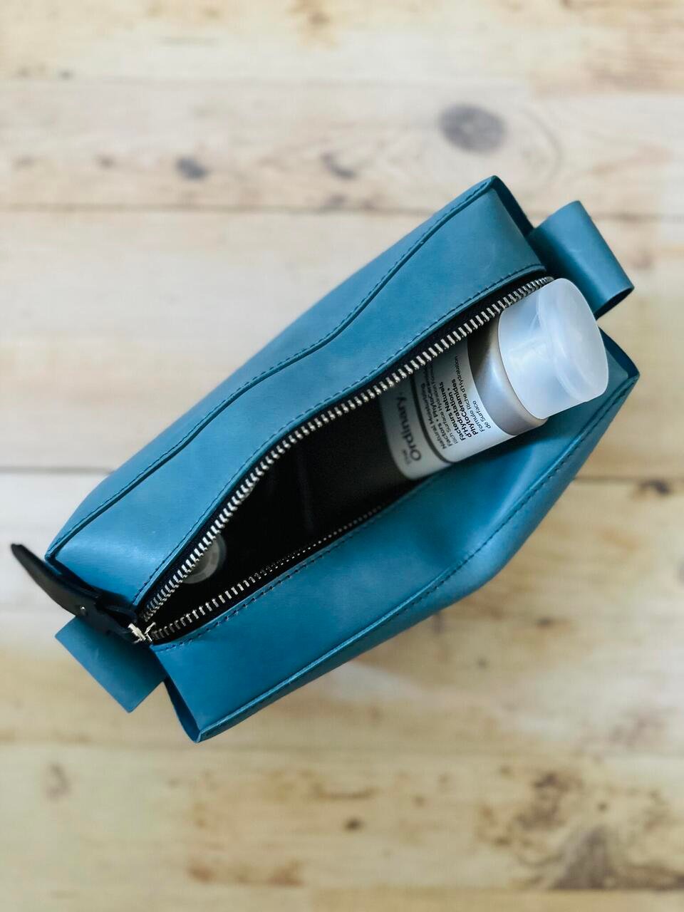 7. Open eleriinseim leather cosmetic bag in Atlantico color with beauty products inside