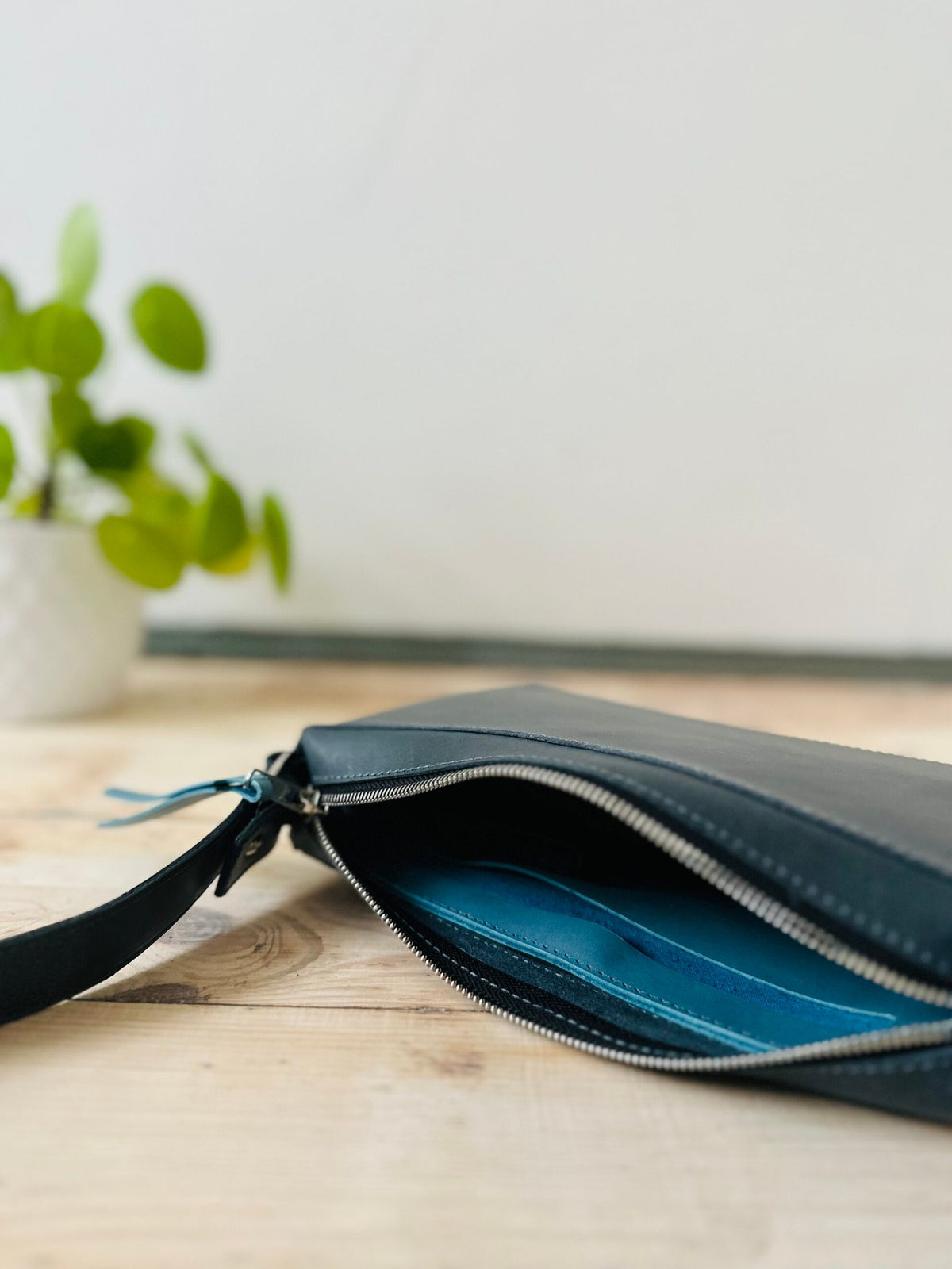 8. Close-up of eleriinseim TOURIST crossbody leather bag in Atlantic blue, focusing on zippered pocket and interior lining