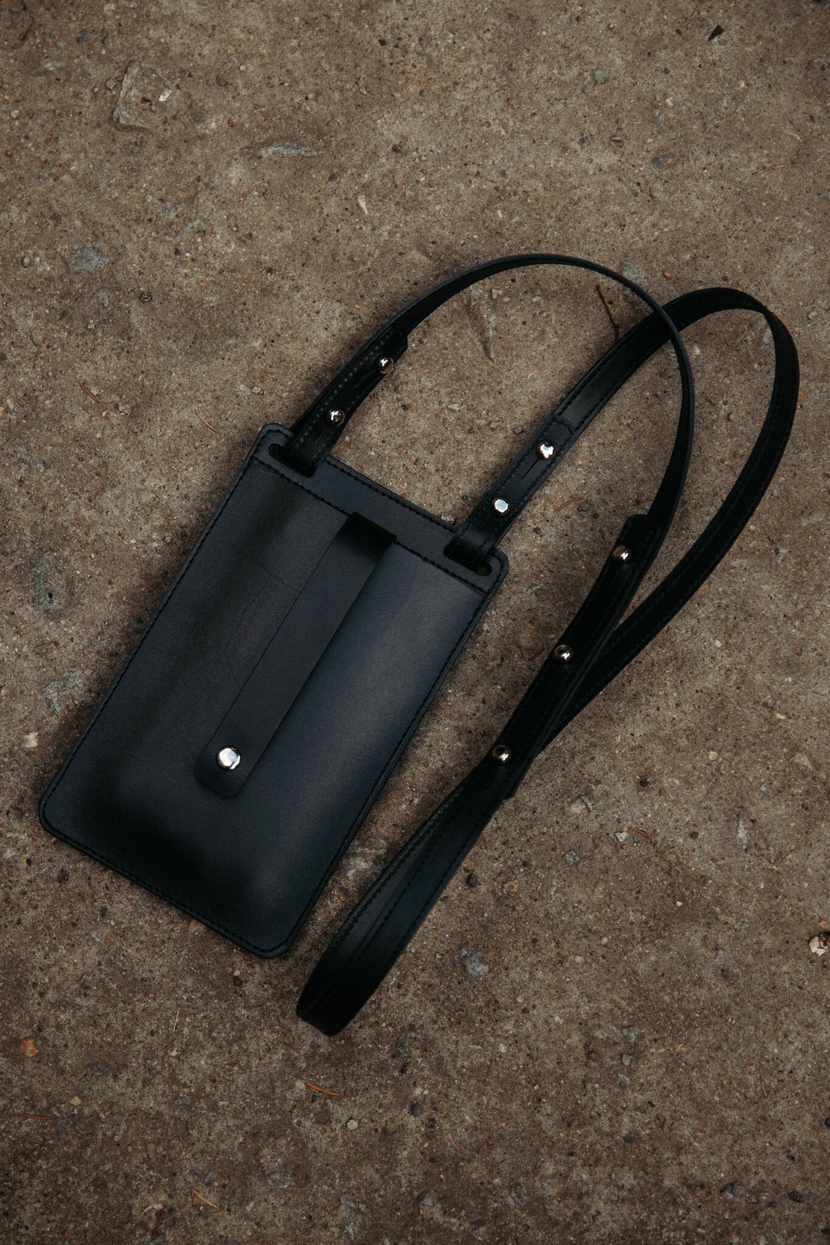 11. Black Stella Soomlais By Your Side phone bag with magnet snap closure and strap on concrete