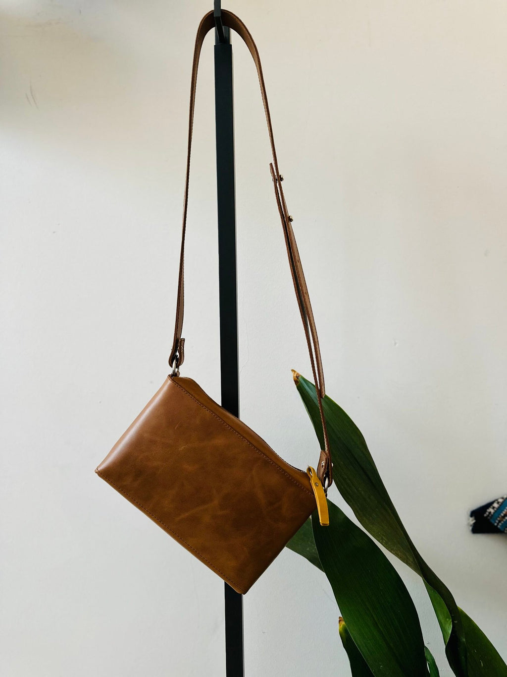 6. Studio shot of eleriinseim TOURIST crossbody leather bag in brown, highlighting adjustable strap and sleek design