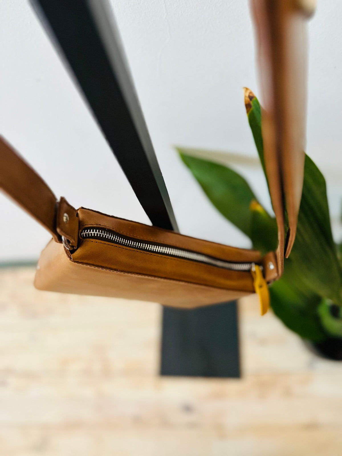 12. Overhead view of eleriinseim TOURIST crossbody leather bag in brown, highlighting adjustable strap and compact design