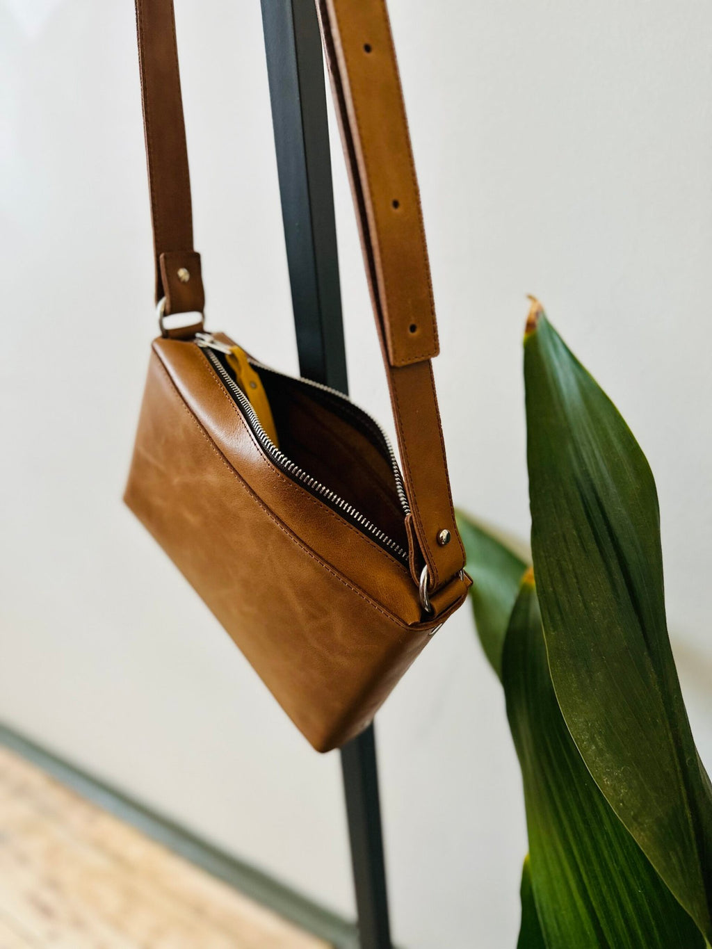 14. Studio shot of eleriinseim TOURIST crossbody leather bag in brown, highlighting open design and interior space